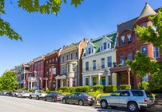 several cars are parked on the street in front of row houses