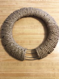 a rope wrapped wreath sitting on top of a wooden table next to a pair of scissors