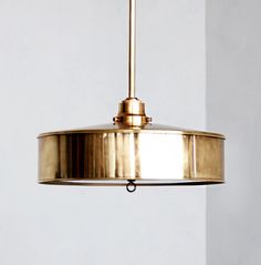 a light fixture hanging from the ceiling in a room with white walls and flooring