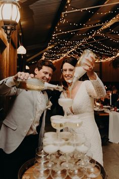 a bride and groom are pouring champagne at their wedding reception