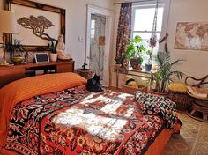 a bed room with a neatly made bed and lots of plants on the windowsill