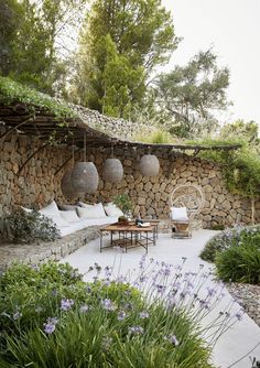 an outdoor seating area with stone walls and plants