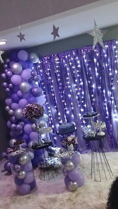 purple and silver balloons are on display in front of a stage set up for a party