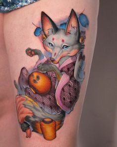 a woman's thigh with an image of a cat and oranges on it