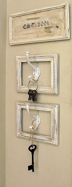 a key holder with two keys hanging from it's sides and a framed photo on the wall