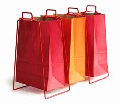 three red, orange and yellow shopping bags on a white background