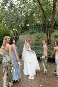 a group of women standing next to each other on top of a brick floored walkway