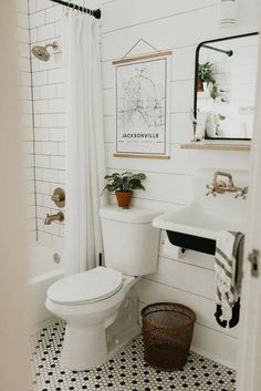 a white toilet sitting next to a bath tub in a bathroom with black and white tiles