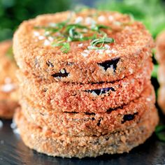 some kind of food that is on top of a black surface with green leaves in the background