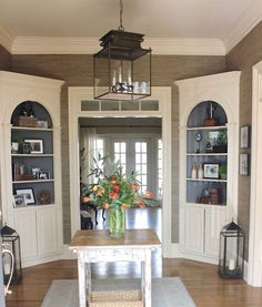 a dining room table with flowers in a vase on it