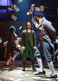 the actors are performing on stage with books flying in the air