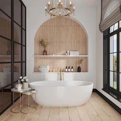 a large white bath tub sitting in a bathroom next to a wooden shelf with candles on it