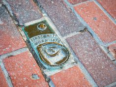 a street sign that is on the side of a brick road with water coming out of it