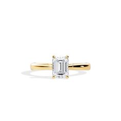 a gold ring with an emerald cut diamond