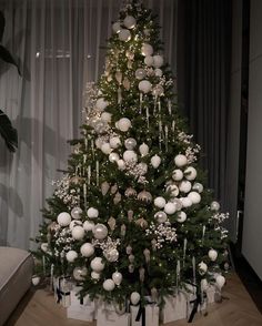 a christmas tree with white balls and ornaments