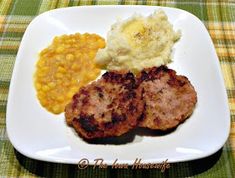 two meat patties, mashed potatoes and corn on a white plate