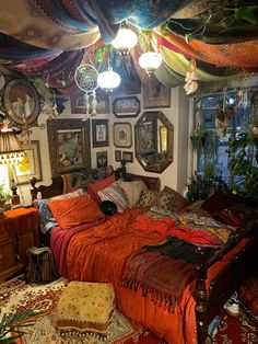 a bed room with a neatly made bed and lots of pictures on the wall above it