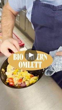 a man in an apron is cooking omelet