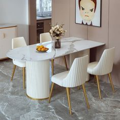 a dining room table with two chairs and a bowl of fruit on the table next to it