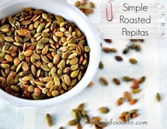 a white bowl filled with pumpkin seeds on top of a table