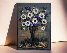 a vase with flowers painted on it sitting next to a wall