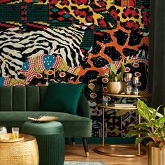 a living room with green velvet couches and colorful wallpaper on the walls behind them