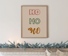 a christmas mantle with stockings and candles in front of a framed art print that says oh hoo