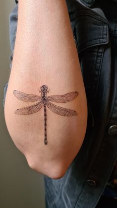 a woman with a tattoo on her stomach has a dragonfly tattooed on her lower back