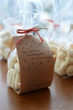 small bags filled with white chocolates on top of a wooden table