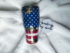 a red, white and blue tumbler with the american flag on it