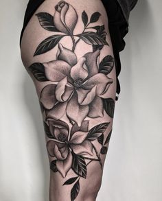 a woman's leg with flowers and leaves on it