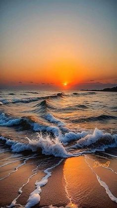 the sun is setting over the ocean with waves coming in to shore and some sand on the beach