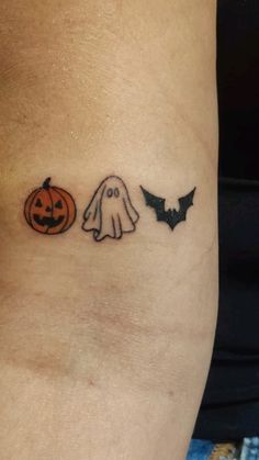 a woman's leg with two halloween tattoos on it