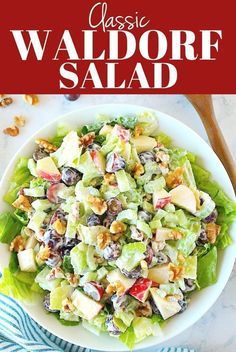 a salad with lettuce, grapes and walnuts in it on a white plate