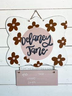 a sign that says delaney jane with flowers on it and the name delaney jane