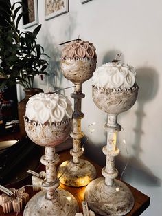 three candles are sitting on a table with other items around them, including one candle holder