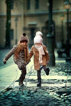 two young children are playing in the rain