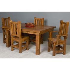 a wooden table with chairs around it and a bowl on top of the dining room table