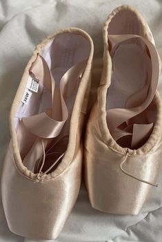 two pairs of ballet shoes with bows on them