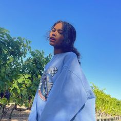 a woman standing in front of some vines