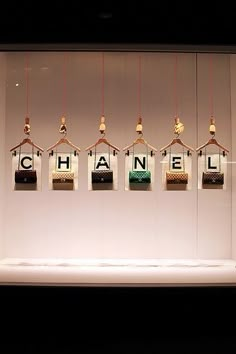 the chanel logo is displayed on display in a store window with glass blocks hanging from it's sides