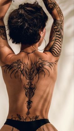 the back of a woman with tattoos on her body