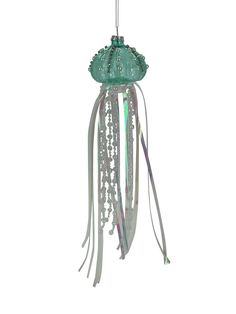 a green and white light hanging from a ceiling fixture with tassels on it