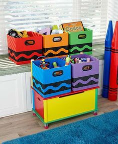 colorful storage bins are stacked on top of each other in front of a window