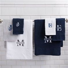 towels hanging on a towel rack with monogrammed letters and initials in white and blue