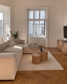 a living room filled with furniture and a flat screen tv on top of a wooden table