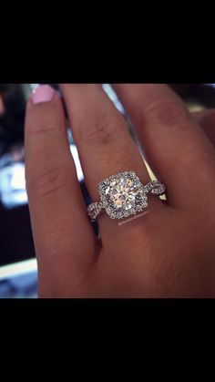 a close up of a person's hand with a diamond ring on their finger