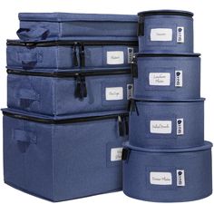 four blue storage containers stacked on top of each other with labels attached to the lids