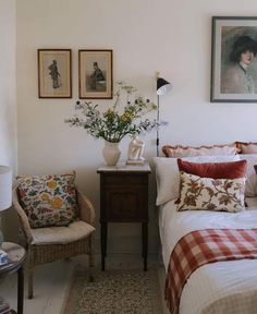 a bedroom with white walls and pictures on the wall