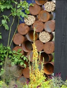 several bowls are stacked on top of each other in front of a black fence and flowers